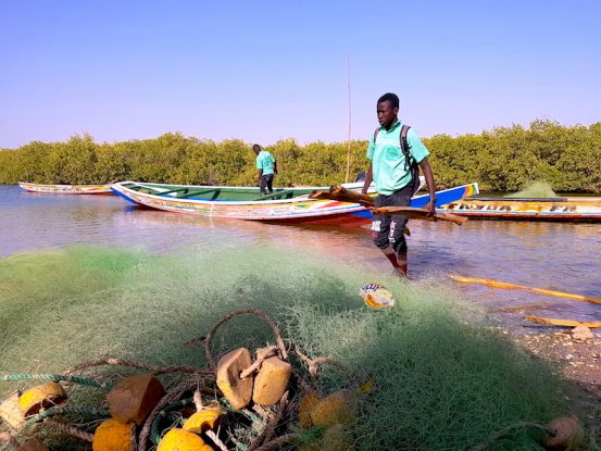 Un filet de pêche et un jeune local sur l'ile de Wandié dans l'Ile de Mar Lodj photo blog voyage tour du monde https://yoytourdumonde.fr
