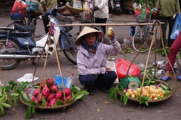 Hanoi-Vietnam: Vendeuse ambulante avec chapeau conique.