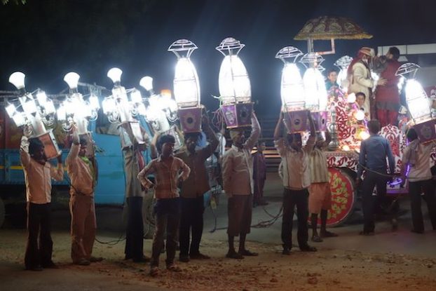 Lors d'un mariage à Agra en Inde des hommes portaient des lumières photo blog voyage tour du monde https://yoytourdumonde.fr