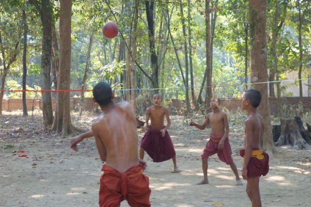 Des jeunes moines bouddhistes jouent au volley ball pres d'une temple bouddhsite du coté de l'ile de l'Ogre photo voyage tour du monde https://yoytourdumonde.fr