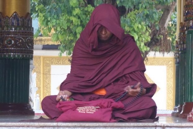 Un moine bouddhiste entrain de mediter dans La Pagode Shwedagon il ressemble cependant un a acteur de star wars photo blog tour du monde https://yoytourdumonde.fr