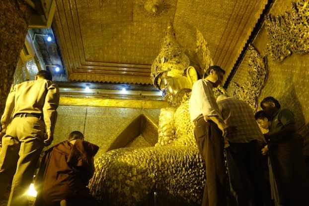 Dans la Pagode de Mahamuni à Mandalay les fideles apportent des feuilles d'or qu'il depose sur le corps du Bouddha. Plus de 15cm d'epaiseur d'or sur le corps du Bouddha photo blog voyage tour du monde https://yoytourdumonde.fr