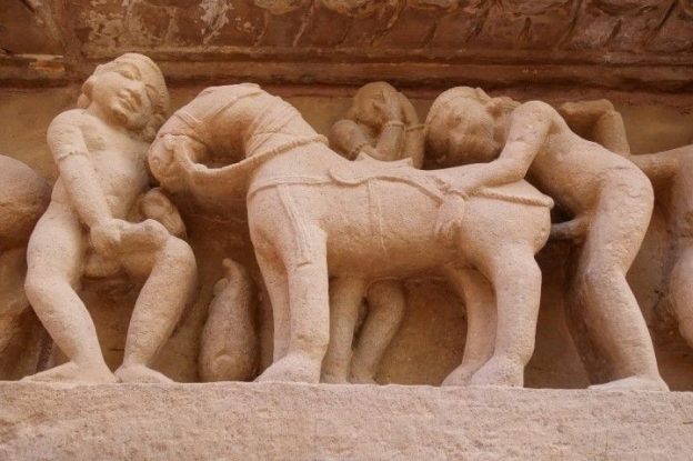 La scene la plus connue des temples de Khajuraho se trouve dans le temple de Lakshmana ou un homme penetrte une jument alors q'une femme regarde choqué, photo blog voyage tour du monde https://yoytourdumonde.fr
